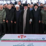 Officials grieve at the funeral of Qasem Soleimani. Hassan Rouhani, Ali Khamenei, and Ebrahim Raisi are seen in the middle of the front row.; modified, khamenei.ir, https://fr.wikipedia.org/wiki/Fichier:Qasem_Soleimani_funeral_2.jpg