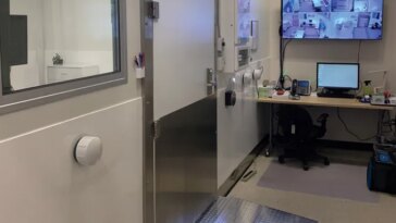 Dans le laboratoire de l'Unité de recherche en physiologie humaine et environnementale de l'Université d'Ottawa. Le mur de gauche a une porte et une fenêtre donnant sur la pièce voisine. Le long du mur du fond se trouve un bureau avec un écran d’ordinateur et, au-dessus, un écran plus grand affichant les images en direct de quatre caméras.