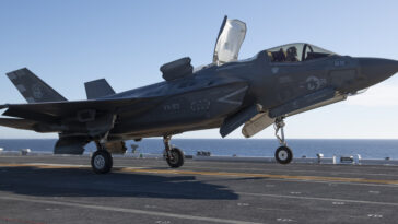 An F-35B Lightning II of Air Test and Evaluation Squadron 23 (VX-23) on the flight deck of JS Kaga (DDH-184) during F-35B developmental testing off Southern California, October 2024. US Navy photo by Dane Wiedmann, public domain, modified, https://commons.wikimedia.org/wiki/File:F-35B_launches_from_JS_Kaga_during_sea_trials-2.jpg