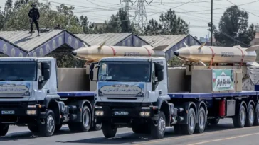 Kheibar Shekan missiles on trucks at the Sacred Defence Week armed forces parade, Tehran, September 22, 2023 (Photo by Mohammad Hossein Ghanbarian / SNN), Attribution licence, modified, https://commons.wikimedia.org/wiki/File:Kheibar_Shekan_missiles_Sacred_Defence_Week_parade_2023.jpg