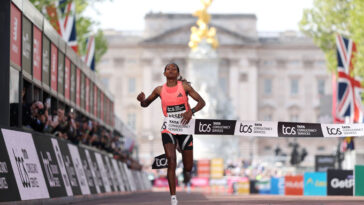 Une femme traverse la bande à la ligne d'arrivée du marathon de Londres du TCS.